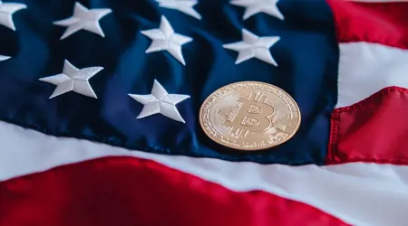 Een close-up foto van de Amerikaanse vlag met een Bitcoin-munt erop